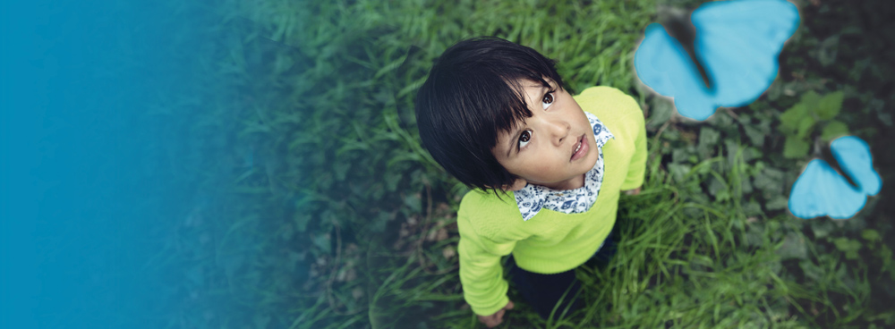 Young child looking up at butterflies